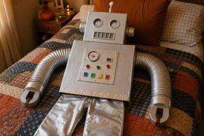 A homemade cardboard-box robot costume laid out ready to wear — AI-generated image